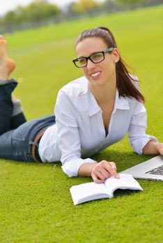 happy young student woman with laptop in city park study