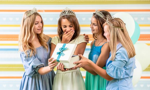 Girl receining a gift on a birthday party with friends