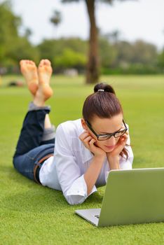 happy young student woman with laptop in city park study