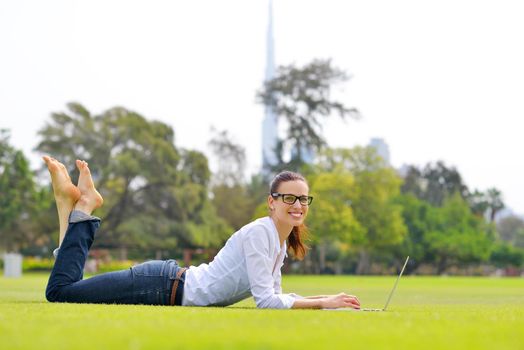 happy young student woman with laptop in city park study