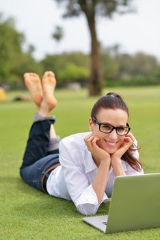 happy young student woman with laptop in city park study