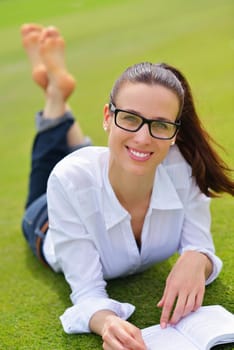 Young student woman reading a book and study in the park