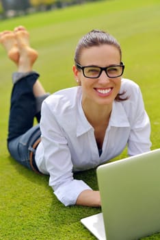 happy young student woman with laptop in city park study