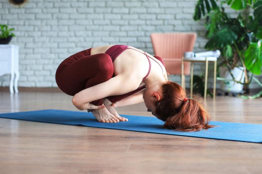 Healthy life. Attractive woman practicing home yoga, working out, wearing sportswear