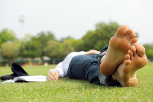 Young student woman reading a book and study in the park