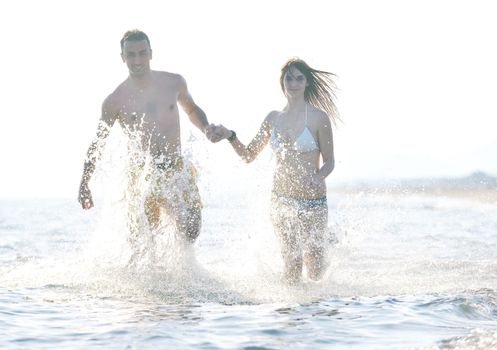 happy young couple have romantic time on beach at sunset