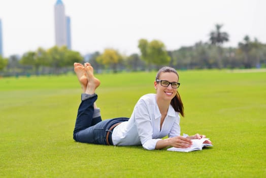 Young student woman reading a book and study in the park