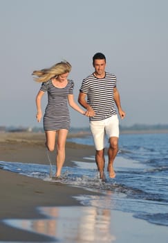 happy young couple have romantic time on beach at sunset