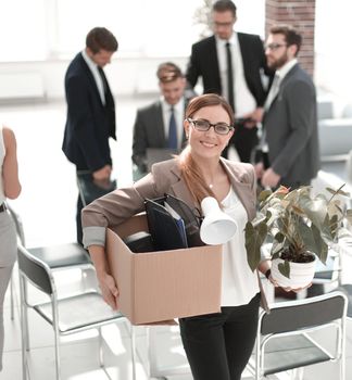 smiling business woman with personal things standing in modern office.first working day