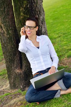 happy young student woman with laptop in city park study