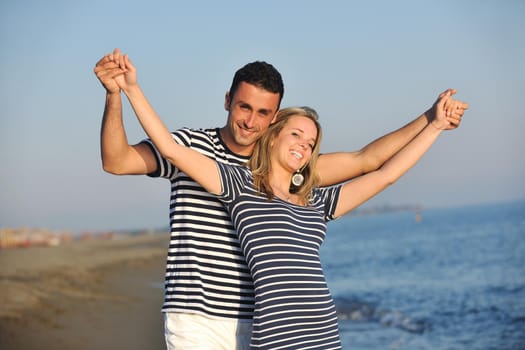 happy young couple have romantic time on beach at sunset