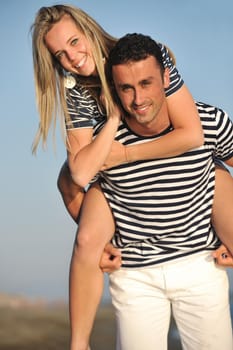 happy young couple have romantic time on beach at sunset