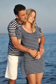 happy young couple have romantic time on beach at sunset