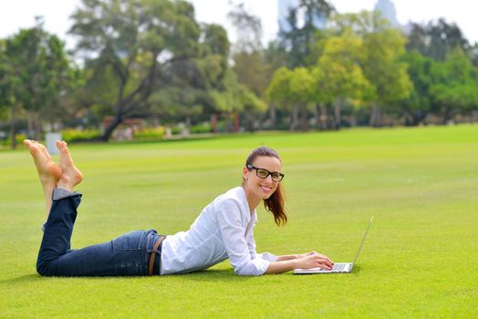 happy young student woman with laptop in city park study