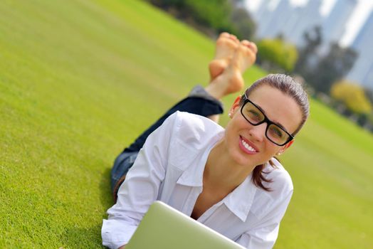 happy young student woman with laptop in city park study