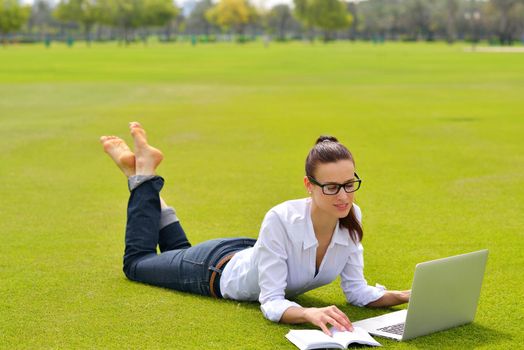 happy young student woman with laptop in city park study