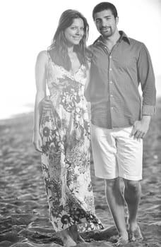 happy young couple have romantic time on beach at sunset