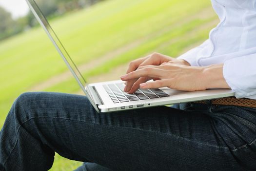 happy young student woman with laptop in city park study