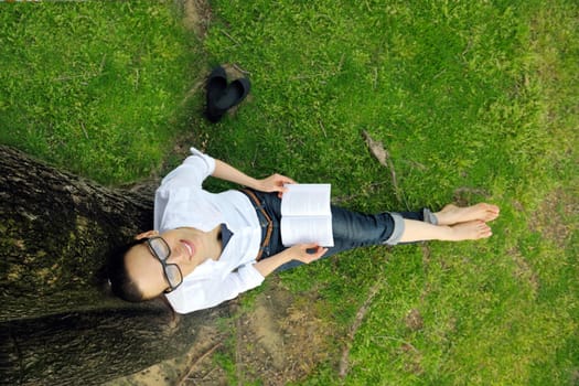 Young student woman reading a book and study in the park