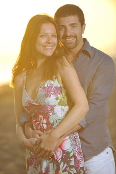 happy young couple have romantic time on beach at sunset