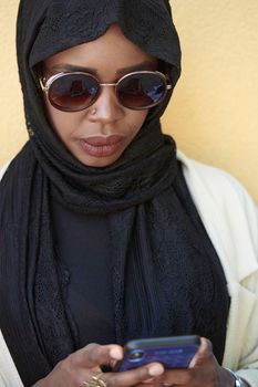 african  business woman using smart phone wearing traditional islamic clothes