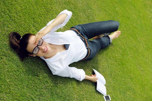 Young student woman reading a book and study in the park