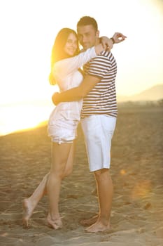 happy young couple have romantic time on beach at sunset