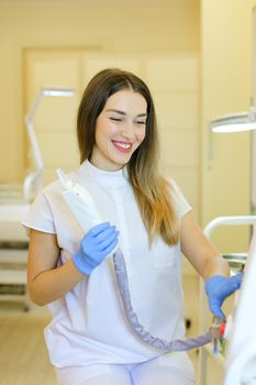 Skilled young permanent makeup artist sitting with laser removal of tatoos device at beauty salon. Concept of cosmetology equipment and cosmetologist.