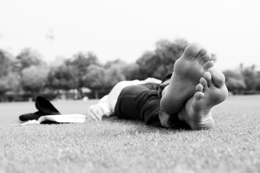 Young student woman reading a book and study in the park