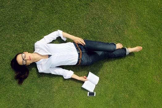 Young student woman reading a book and study in the park