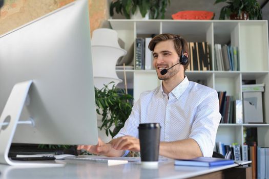 Smiling young business man having video call in office