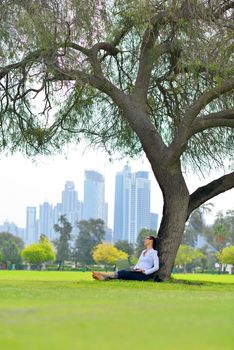 happy young student woman with laptop in city park study