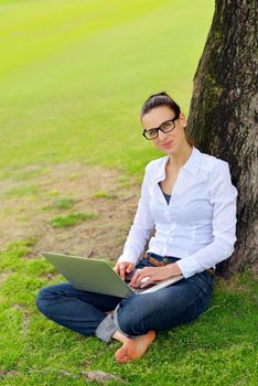 happy young student woman with laptop in city park study