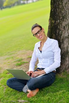 happy young student woman with laptop in city park study