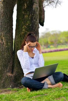 happy young student woman with laptop in city park study