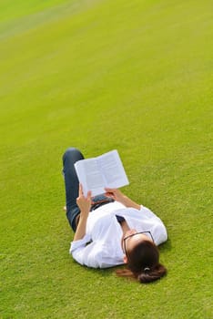 Young student woman reading a book and study in the park