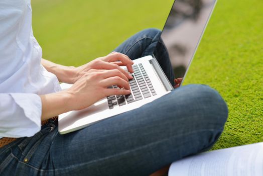 happy young student woman with laptop in city park study