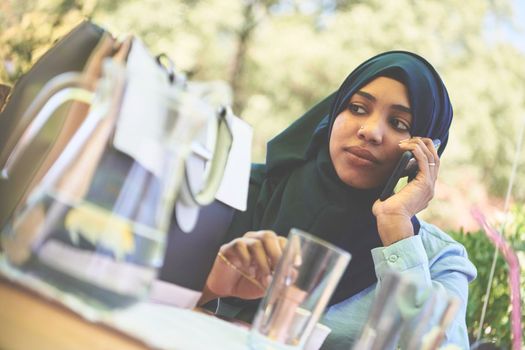 african  business woman using smart phone wearing traditional islamic clothes