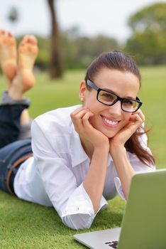 happy young student woman with laptop in city park study