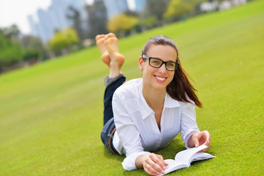 Young student woman reading a book and study in the park