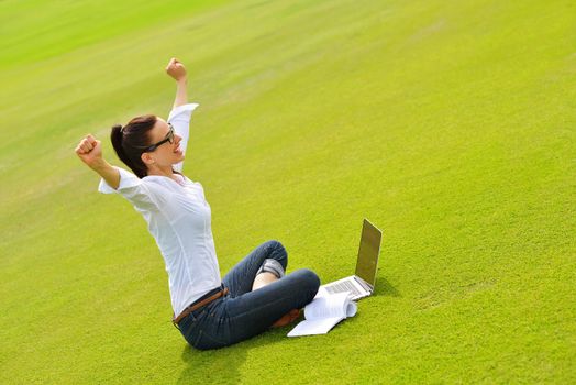 happy young student woman with laptop in city park study