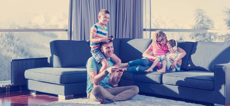 Happy family. Father, mother and children playing a video game Father and son playing video games together on the floor