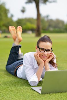 happy young student woman with laptop in city park study