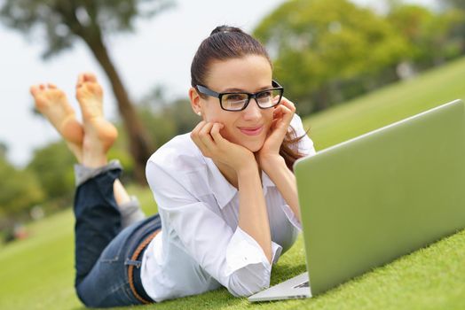 happy young student woman with laptop in city park study