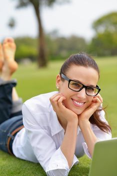 happy young student woman with laptop in city park study