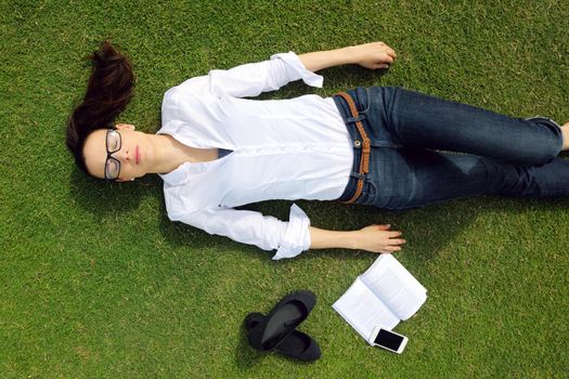 Young student woman reading a book and study in the park