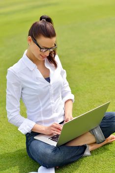 happy young student woman with laptop in city park study