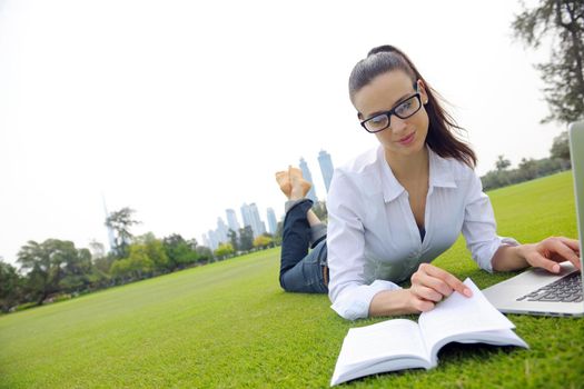 happy young student woman with laptop in city park study