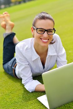 happy young student woman with laptop in city park study