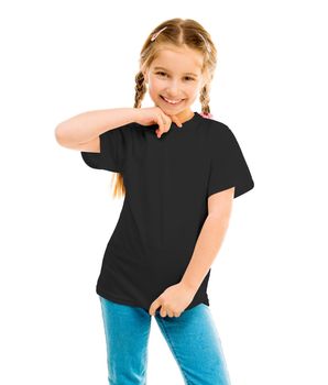 cute little girl in a blacke T-shirt and blue jeans on a white background shows a T-shirt on
